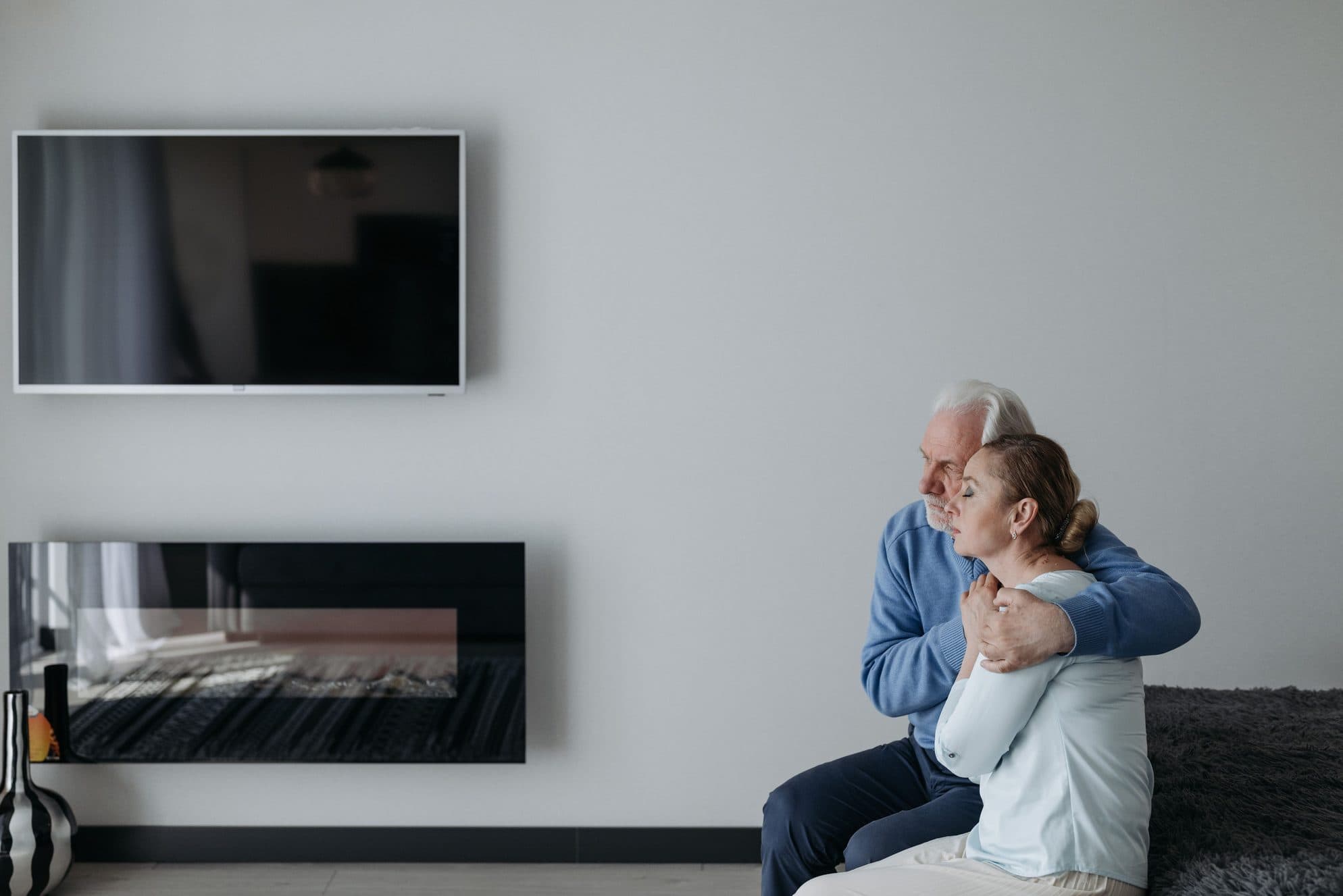 A caregiver sitting with her mother in a living room.
